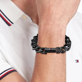 Ανδρικό ατσάλινο βραχιόλι Tommy Hilfiger 2790639 χειροπέδα σε μαύρο χρώμα και σχέδιο αλυσίδας με διαγώνια πλέξη, φορεμένο.