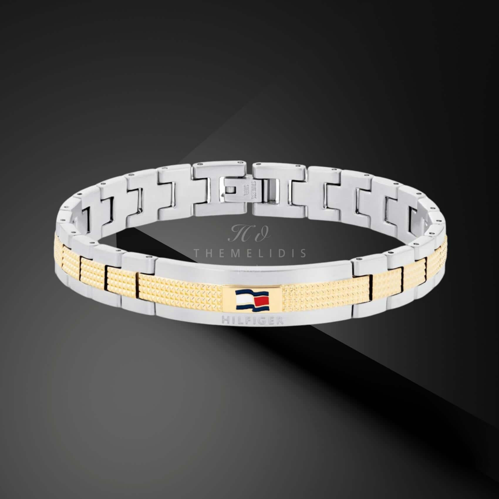 Ανδρικό ατσάλινο βραχιόλι Tommy Hilfiger 2790642 χειροπέδα δίχρωμο σε ασημένιο χρώμα με χρυσές λεπτομέρεις και σχέδιο μπρασελέ, σε μαύρο φόντο.