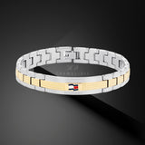 Ανδρικό ατσάλινο βραχιόλι Tommy Hilfiger 2790642 χειροπέδα δίχρωμο σε ασημένιο χρώμα με χρυσές λεπτομέρεις και σχέδιο μπρασελέ, σε μαύρο φόντο.
