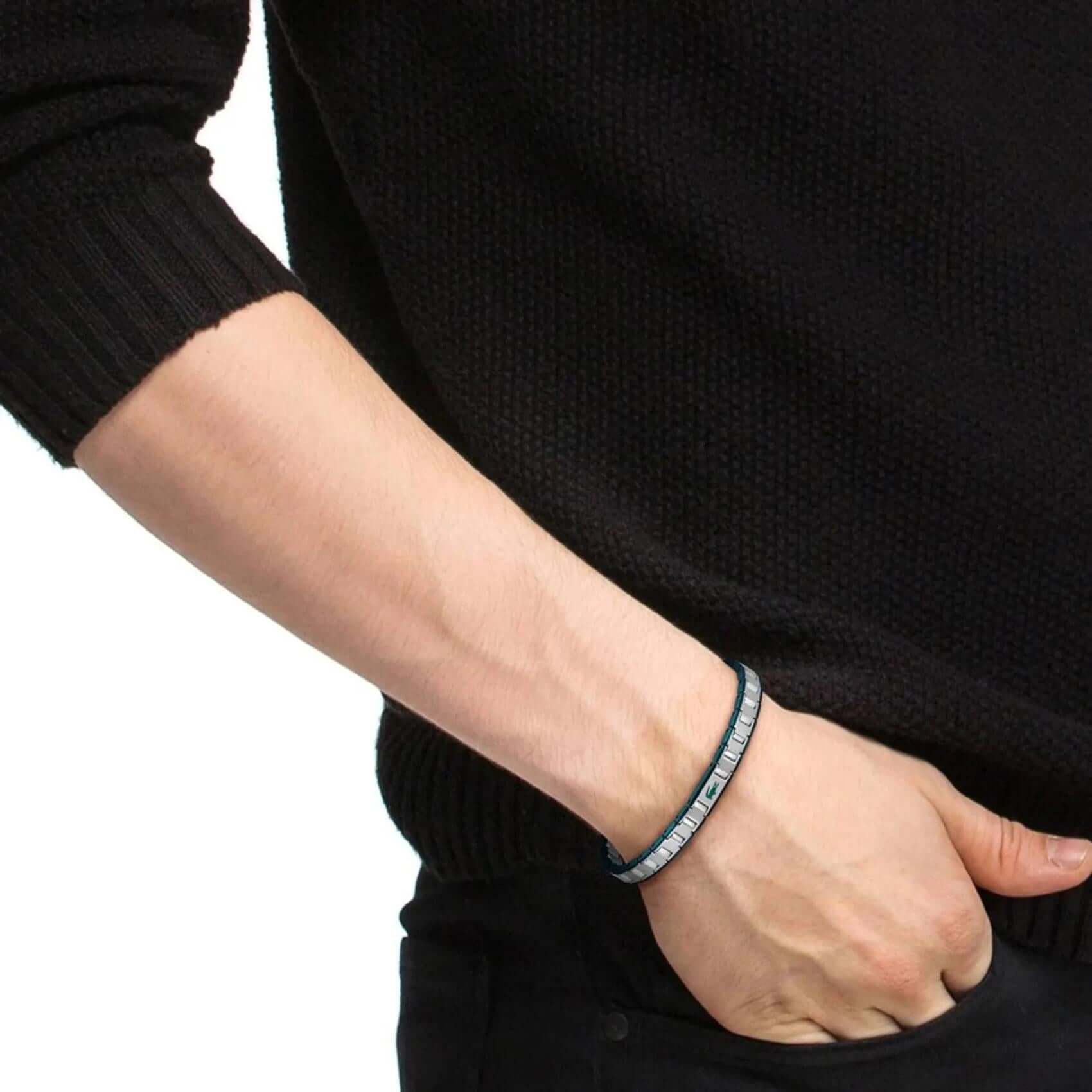 Ανδρικό βραχιόλι χειροπέδα Lacoste 2040590 φορεμένο σε ασημί χρώμα με πράσινες λεπτομέρειες.