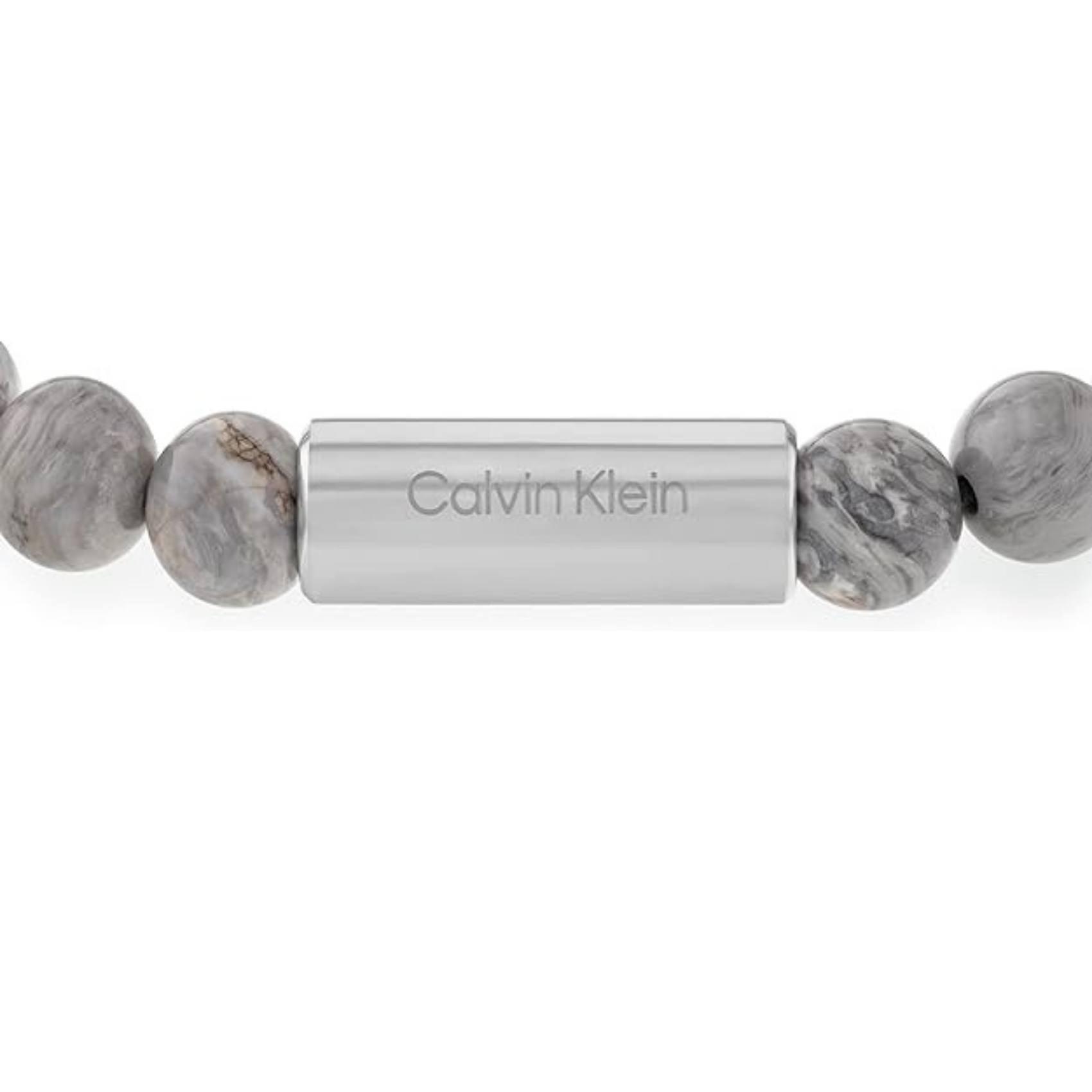 Ανδρικό βραχιόλι Calvin Klein 35000427 με χάντρες ίασπις σε γκρι χρώμα διακοσμημένο με κυλινδρικό στοιχείο από ανοξείδωτο ατσάλι σε ασημί χρώμα.