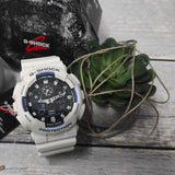Καταδυτικό ρολόι χρονογράφος Casio G-Shock GA-100B-7AER με λευκό καουτσούκ λουράκι, μαύρο καντράν με μπλε λεπτομέρειες και στεγανότητα 20ATM-200Μ.