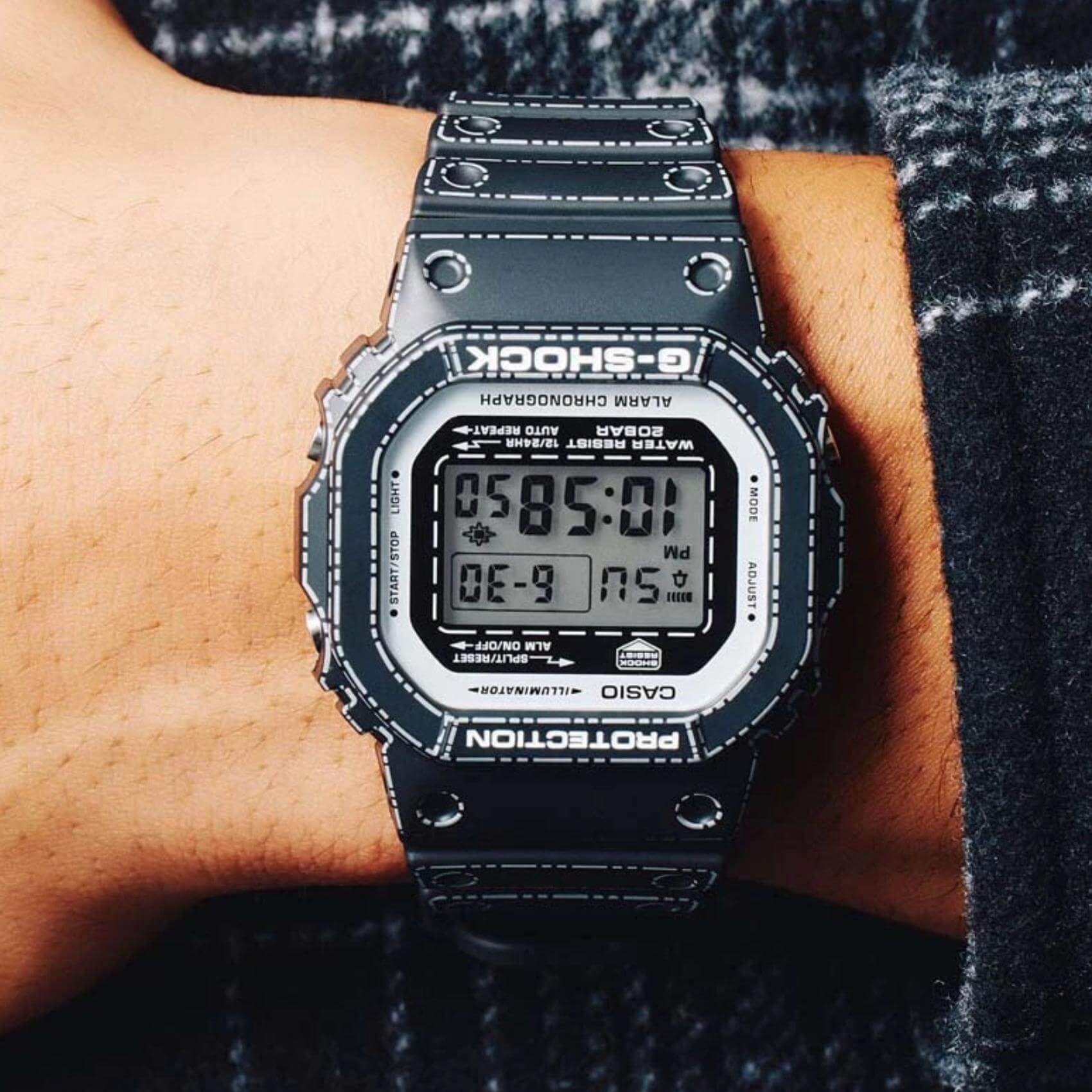Ρολόι Casio G-Shock DW-5600RGM-1ER φορεμένο στον καρπό με μαύρο καουτσούκ λουράκι και γκρι ψηφιακή οθόνη.