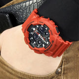 Καταδυτικό ανδρικό ρολόι Casio G-Shock GA-100B-4AER φορεμένο στον καρπό με κόκκινο καουτσούκ λουράκι και μαύρο καντράν.