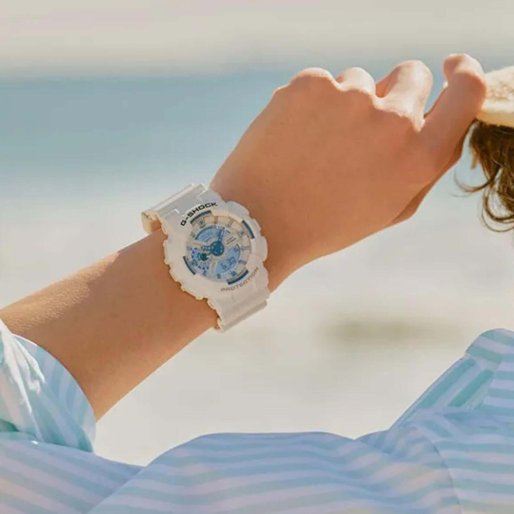 Ανδρικό ρολόι Casio G-Shock GA-110HDS-7AER φορεμένο στον καρπό με λευκό καουτσούκ λουράκι και μπλε καντράν.