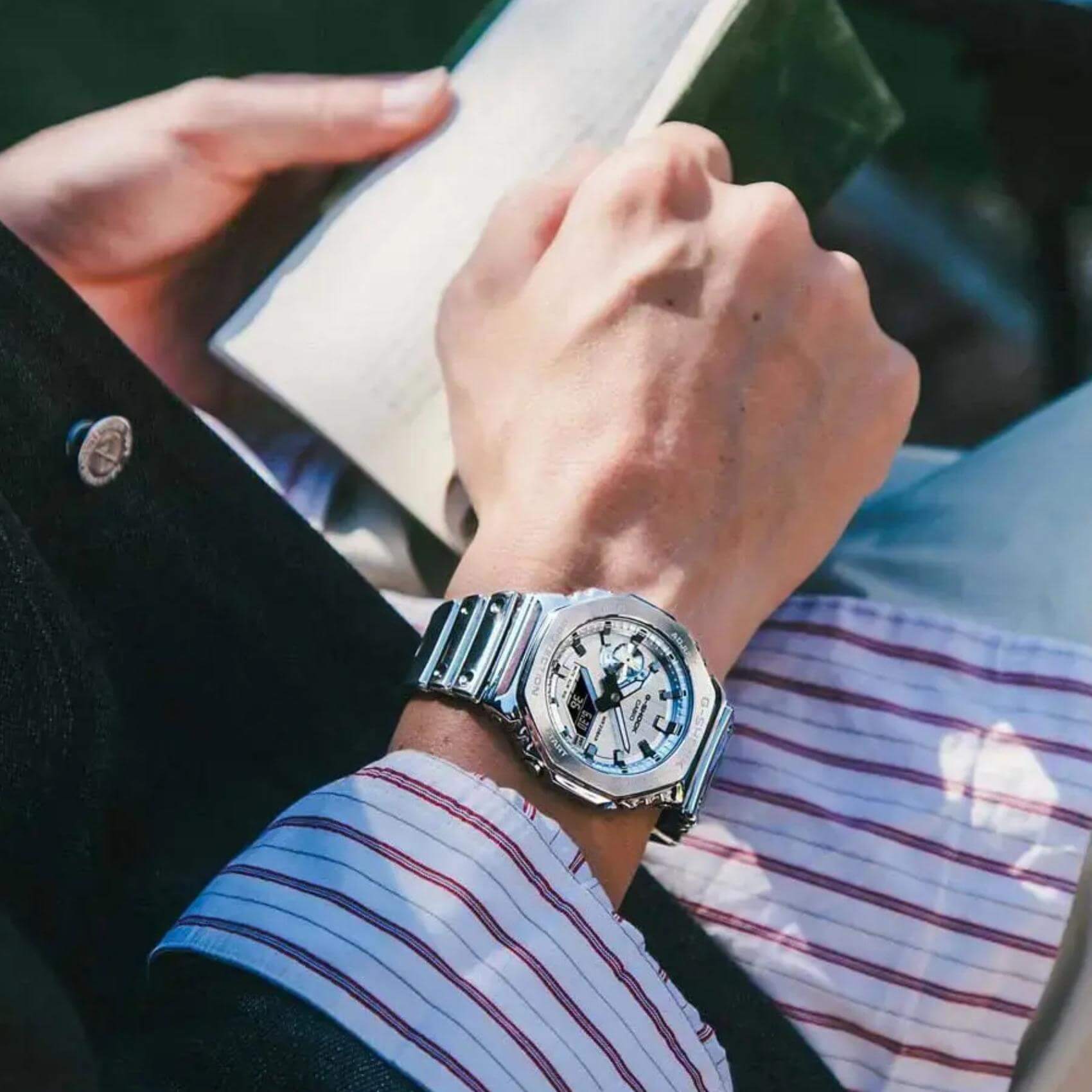 Ανδρικό ρολόι Casio G-SHOCK GM-2100YM-8AER φορεμένο στον καρπό με ασημί καουτσούκ λουράκι και ασημί καντράν.