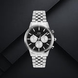 Daniel Wellington DW00100873 ανδρικό ρολόι με ασημί ατσάλινο μπρασελέ, μαύρο καντράν διαμέτρου 42mm και λευκές λεπτομέρειες.