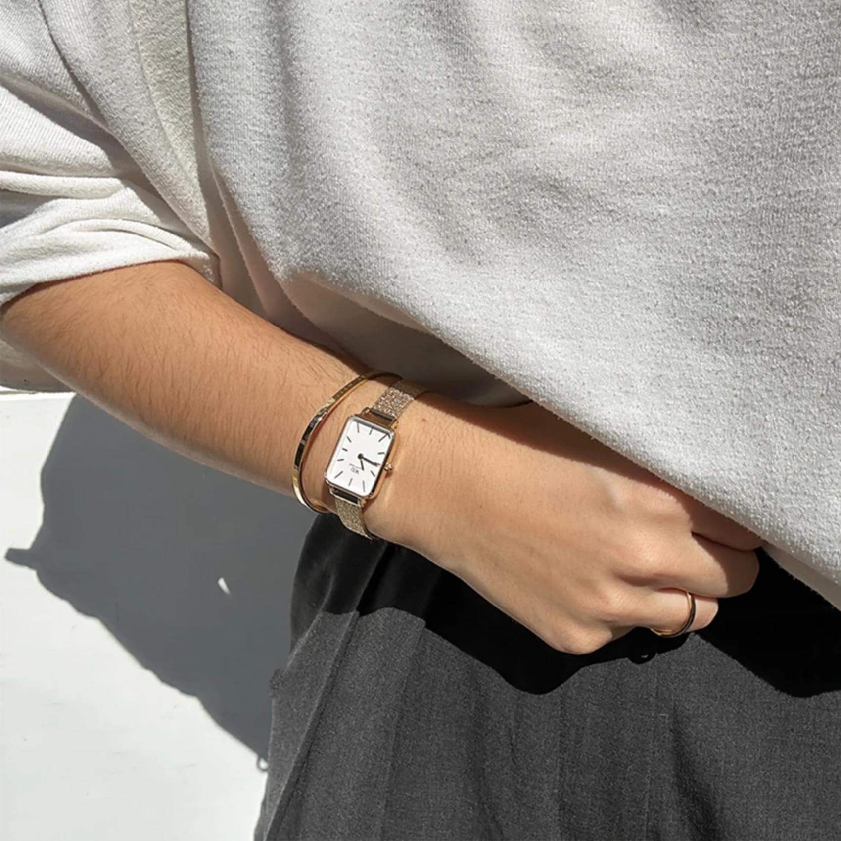 Ρολόι Daniel Wellington Quadro Evergold DW00100556 με χρυσό ατσάλινο μπρασελέ, άσπρο καντραν, μηχανισμό μπαταρίας και τετράγωνο σχήμα διάβροχο στις 3ΑΤΜ-30Μ.
