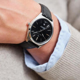 Ανδρικό ρολόι Gant Abington G201002 φορεμένο στον καρπό, με μαύρο δερμάτινο λουράκι και μαύρο καντράν.