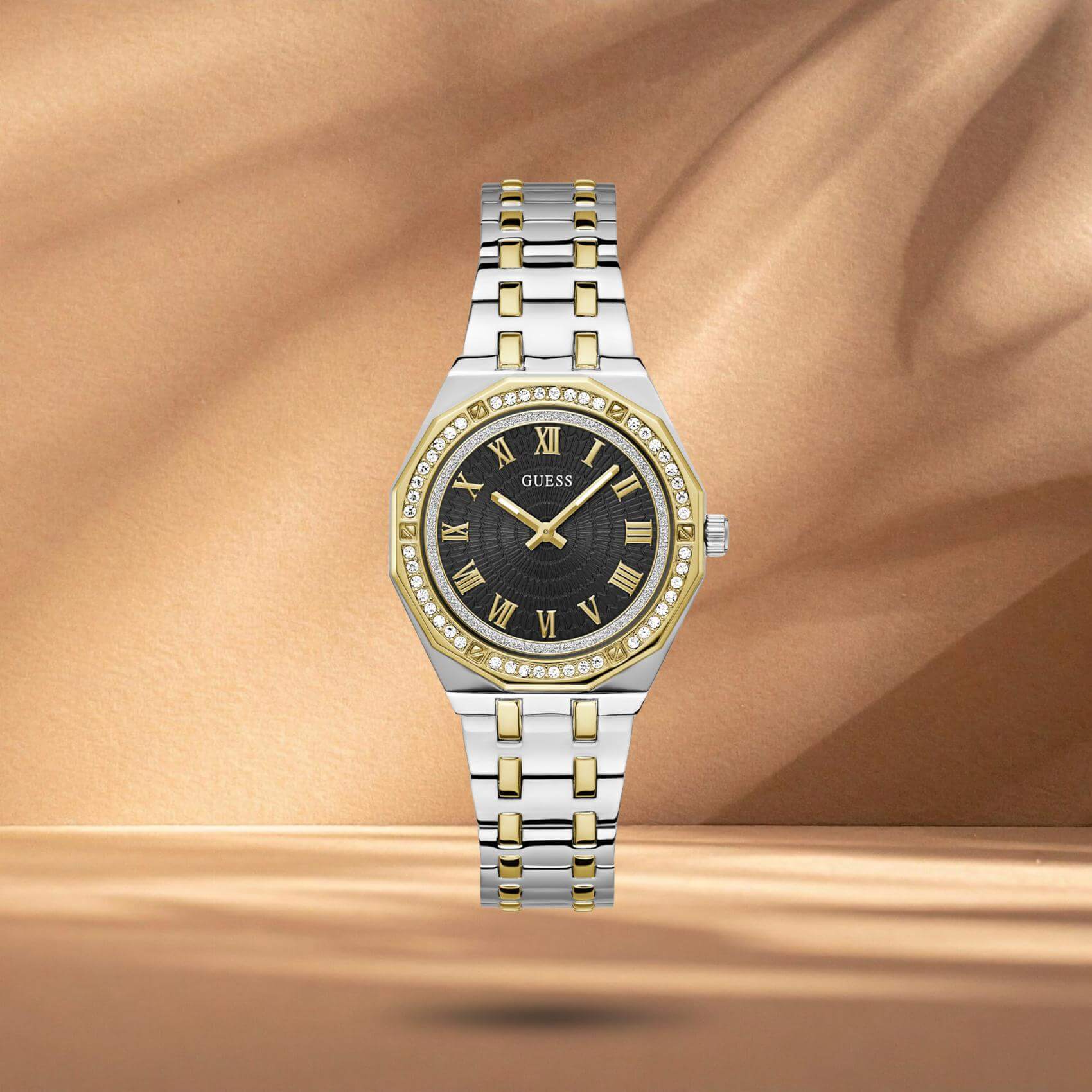 Guess GW0770L4 γυναικείο ρολόι με δίχρωμο ατσάλινο μπρασελέ σε ασημί και χρυσό χρώμα, μαύρο καντράν διαμέτρου 38mm, χρυσές λεπτομέρειες και στεφάνη διακοσμημένη με ζιργκόν.