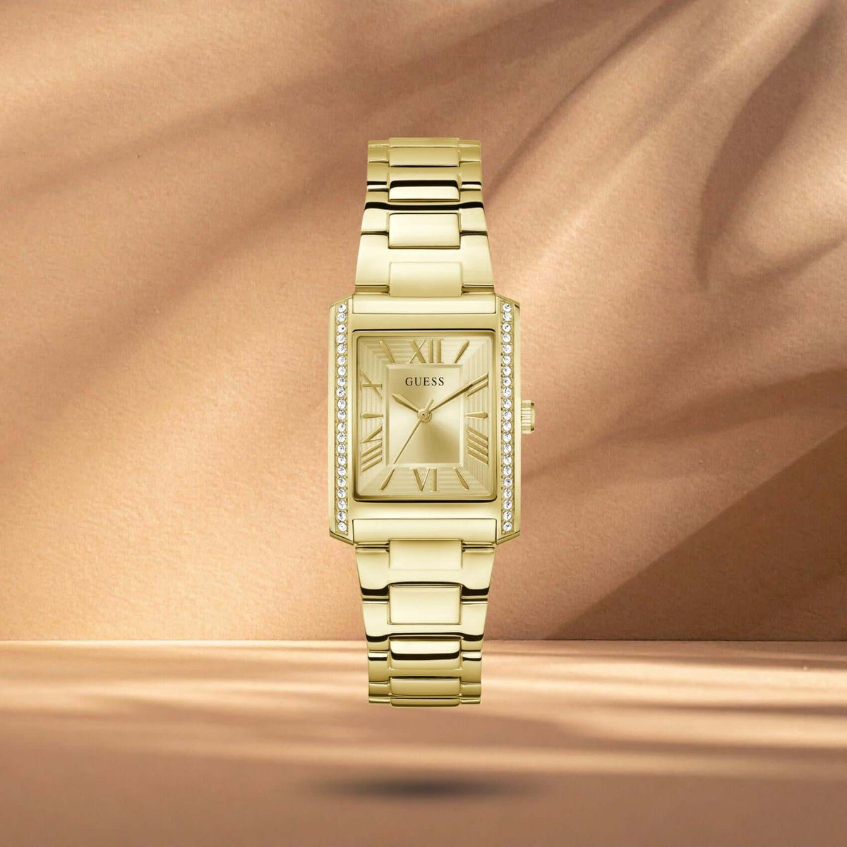 Guess GW0874L4 γυναικείο ρολόι με χρυσό ατσάλινο μπρασελέ, χρυσό τετράγωνο καντράν 27mm και στεφάνη διακοσμημένη με ζιργκόν.