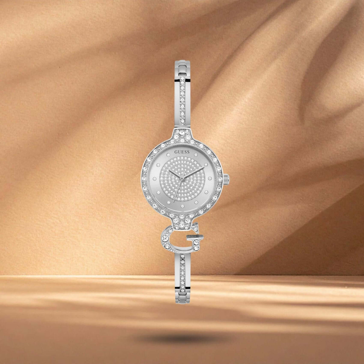 Guess GW0929L1 γυναικείο ρολόι με ασημί ατσάλινο μπρασελέ σε ιδιαίτερο σχέδιο βραχιολιού, ασημί καντράν διαμέτρου 28mm και στεφάνη διακοσμημένη με ζιργκόν.