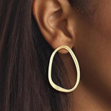 Μοντέλο φορά τα γυναικεία σκουλαρίκια–κρίκους Calvin Klein 35000451 σε χρυσό χρώμα.