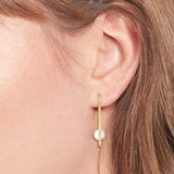 Γυναικεία επιχρυσωμένα σκουλαρίκια κρίκοι Tommy Hilfiger με μαργαριτάρια φορεμένα στο αυτί.