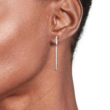 Γυναικεία ασημί σκουλαρίκια Tommy Hilfiger με μακρύ κρεμαστό, φορεμένα.