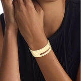 Γυναικεία χειροπέδα Calvin Klein 35000673 σε χρυσό χρώμα από ανοξείδωτο ατσάλι με στοιχεία από το λογότυπο της εταιρίας, φορεμένη