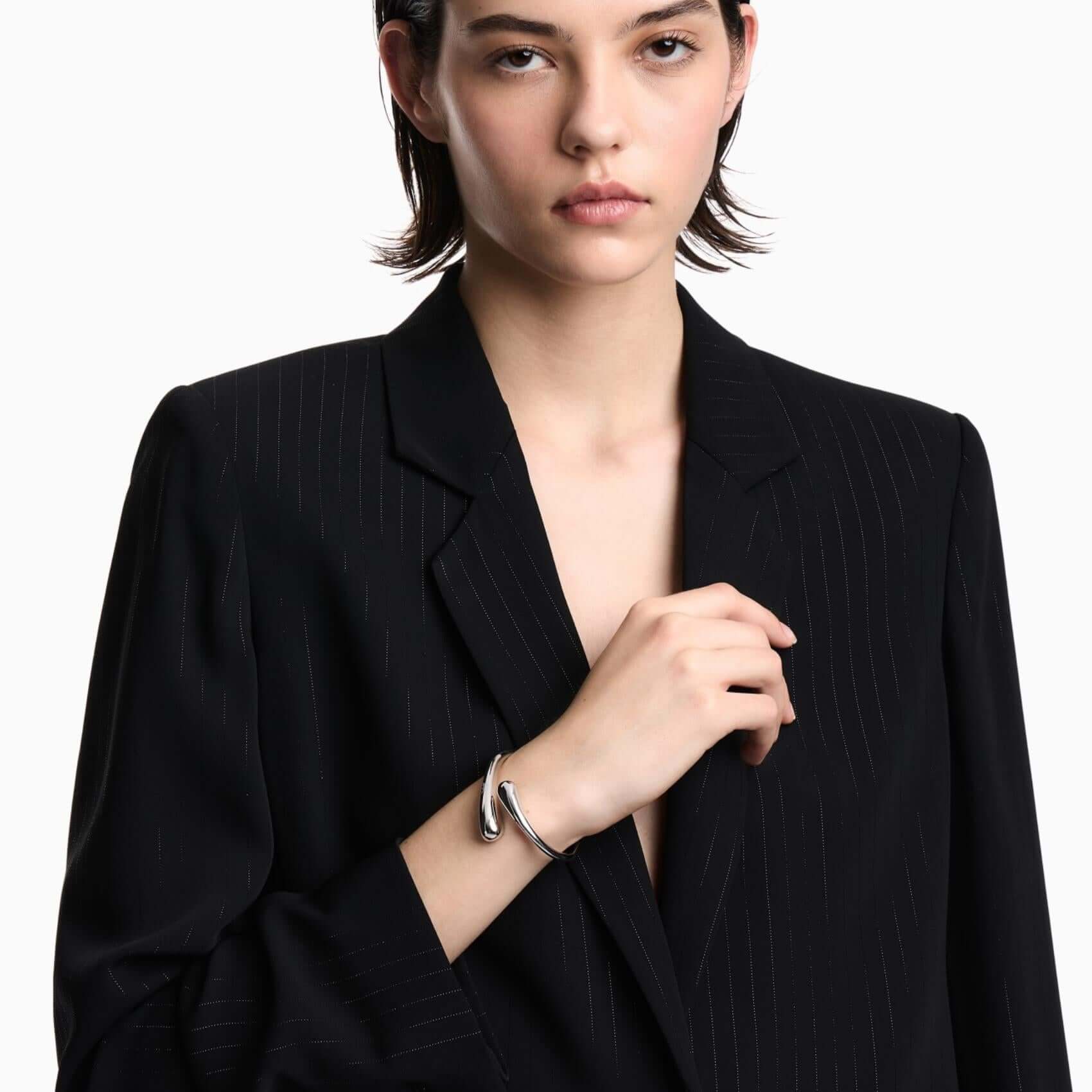 Γυναικεία χειροπέδα Emporio Armani Iconic Trend EGS3340040 φορεμένη στον καρπό, από ορείχαλκο σε ασημί χρώμα με ανοιχτό minimal σχεδιασμό.