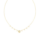 Λεπτομέρεια από το γυναικείο κολιέ Guess Aurora JUBN06238JWYGT/U σε χρυσό χρώμα με κρεμαστά charms, πέτρες και λογότυπο.