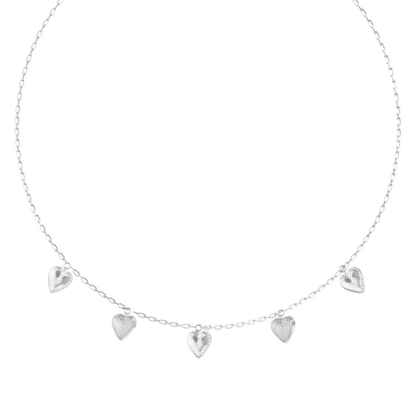 Λεπτομέρεια από το γυναικείο κολιέ Guess By Your Side JUBN06081JWRHT/U από ανοξείδωτο ατσάλι σε ασημί χρώμα με κρεμαστές καρδιές, ζιργκόν και λογότυπο Guess.