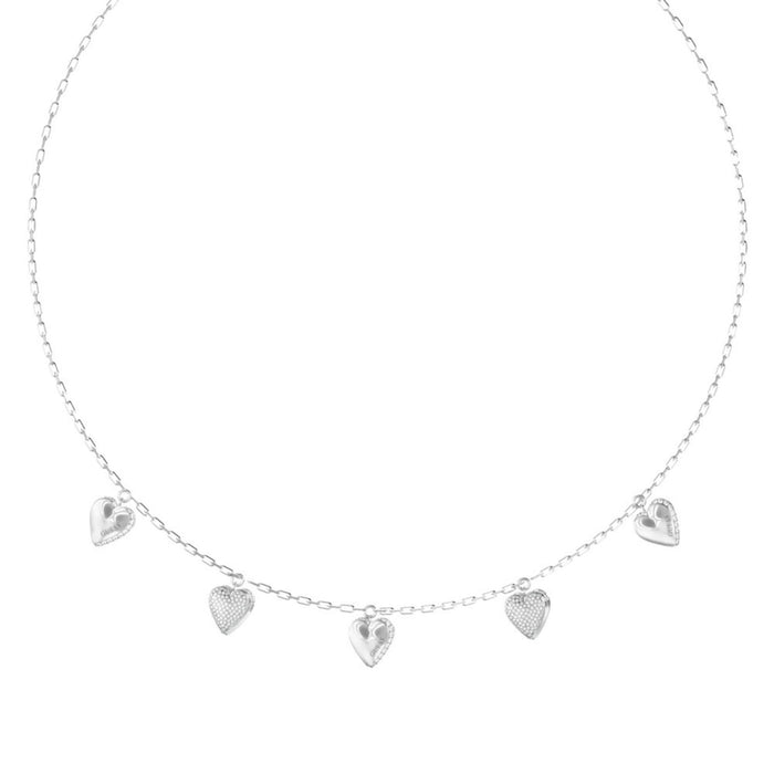 Λεπτομέρεια από το γυναικείο κολιέ Guess By Your Side JUBN06081JWRHT/U από ανοξείδωτο ατσάλι σε ασημί χρώμα με κρεμαστές καρδιές, ζιργκόν και λογότυπο Guess.