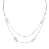 Γυναικείο κολιέ Lacoste 2040469 κατασκευασμένο από ανοξείδωτο ατσάλι σε ασημί χρώμα. Το κολιέ περιλαμβάνει δύο λεπτές αλυσίδες διαφορετικού μήκους 40-45cm με μοτίφ από ζιργκόν που αναπαριστούν τον εμβληματικό κροκόδειλο της Lacoste.