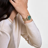 Γυναικείο ρολόι Daniel Wellington Crystalline Bezel Evergold Green DW00100824 φορεμένο με χρυσό ατσάλινο μπρασελέ και πράσινο φίλντισι καντράν.
