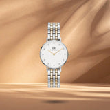 Γυναικείο ρολόι Daniel Wellington Petite Lumine DW00100616 με δίχρωμο μπρασελέ σε ασημί-χρυσό χρώμα από ανοξείδωτο ατσάλι, λευκό στρογγυλό καντράν διαμέτρου 28mm και χρυσούς δείκτες.
