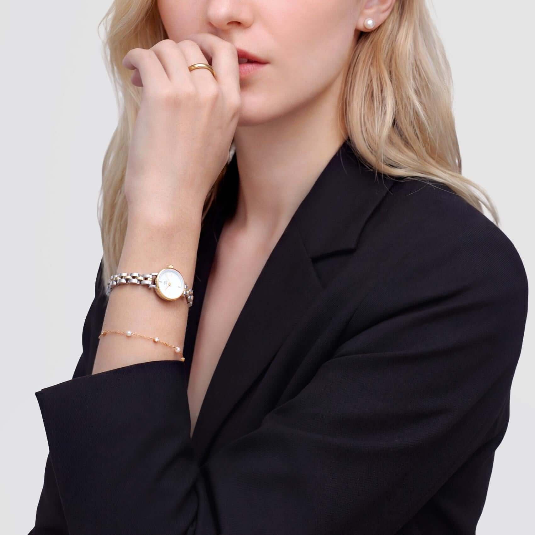 Γυναικείο ρολόι Daniel Wellington Petite Mini DW00100923 φορεμένο με δίχρωμο ατσάλινο μπρασελέ σε ασημί-χρυσό χρώμα, λευκό στρογγυλό καντράν και χρυσούς δείκτες.