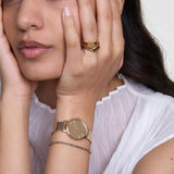 Γυναικείο ρολόι Daniel Wellington Petite Reflection Gold DW00100797 φορεμένο με χρυσό ατσάλινο μπρασελέ και χρυσό καντράν.