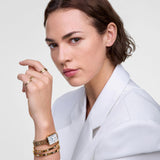 Γυναικείο ρολόι Daniel Wellington Quadro Roman Numerals DW00100861 φορεμένο με χρυσό ατσάλινο μπρασελέ και λευκό καντράν με μπλε δείκτες.