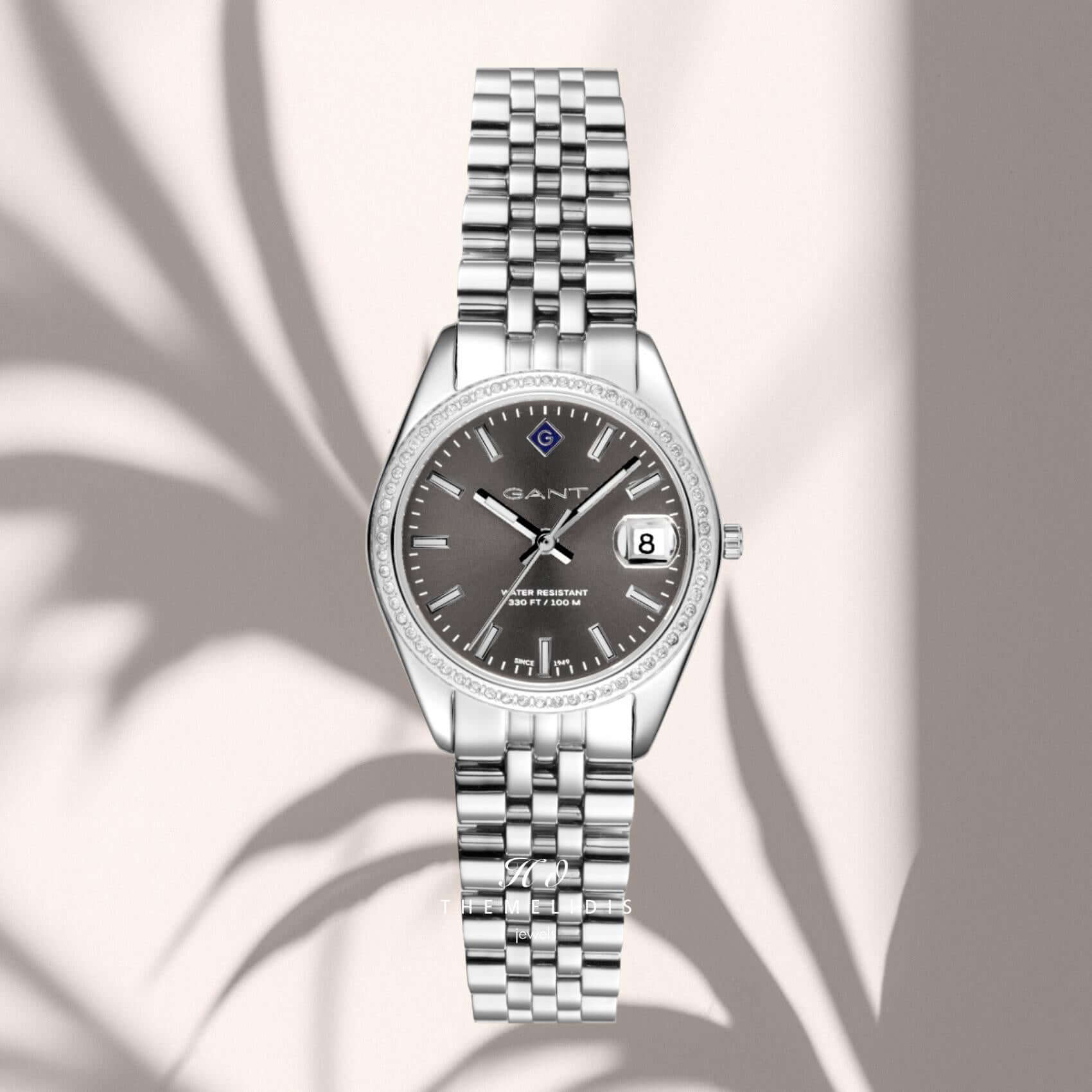Γυναικείο ρολόι Gant Sussex Mini Bijou G181101 με ασημί μπρασελέ και γκρι καντράν 28mm με ζιργκόν, σε μπεζ φόντο.
