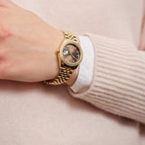 Γυναικείο ρολόι Gant Sussex Mini Bijou G181103 με χρυσό μπρασελέ και καφέ καντράν 28mm με ζιργκόν, φορεμένο.