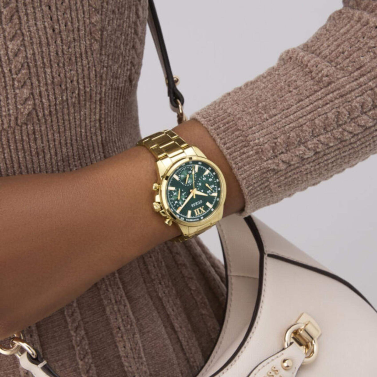 Γυναικείο ρολόι Guess Bailey GW0933L6 φορεμένο με χρυσό ατσάλινο μπρασελέ, πράσινο καντράν και χρυσές λεπτομέρειες.