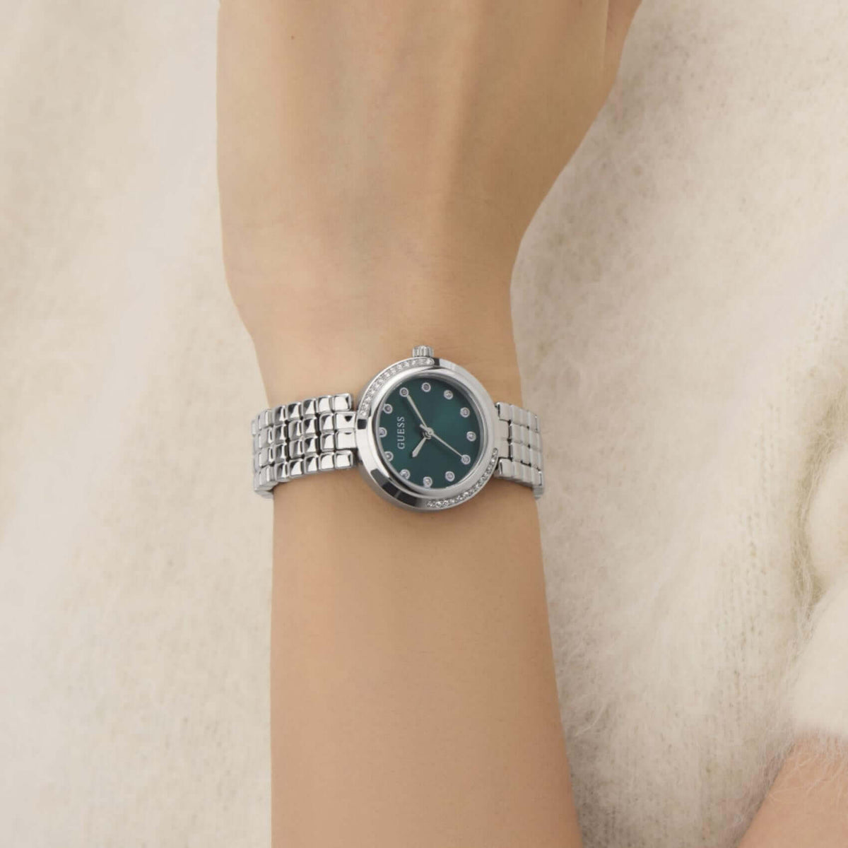Γυναικείο ρολόι Guess Clara GW0930L1 φορεμένο με ασημί ατσάλινο μπρασελέ, πράσινο καντράν και στεφάνη με ζιργκόν.