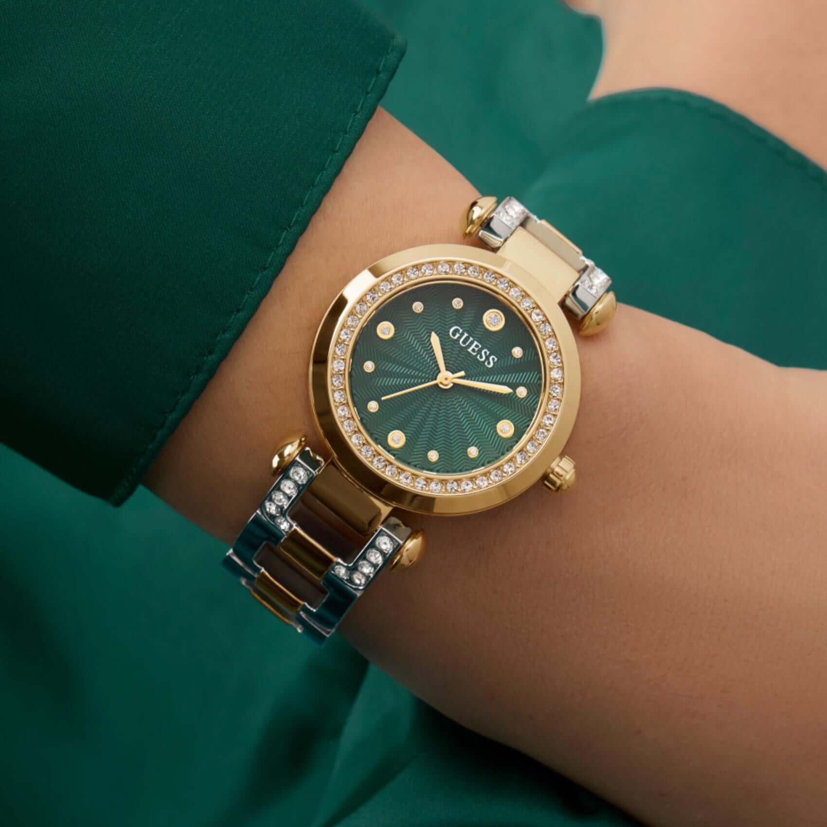 Γυναικείο ρολόι Guess Ginger GW0869L1 φορεμένο με δίχρωμο μπρασελέ ιδιαίτερου σχεδίου σε ασημί και χρυσό χρώμα, πράσινο καντράν και ζιργκόν.