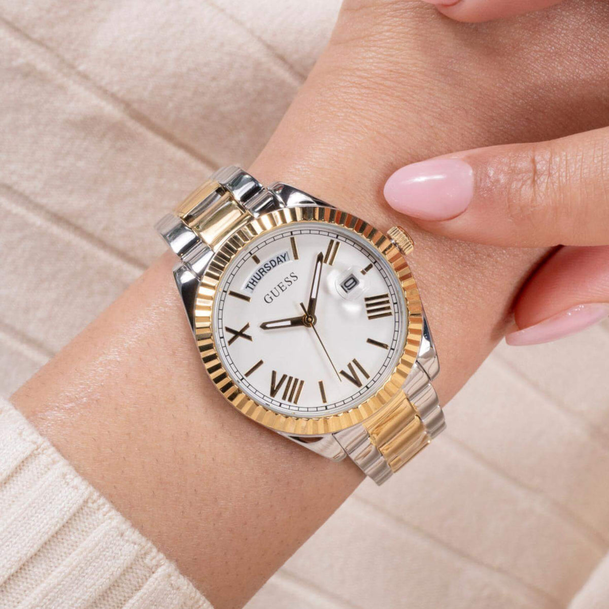 Γυναικείο ρολόι Guess Luna GW0308L6 φορεμένο με δίχρωμο μπρασελέ σε ασημί και χρυσό χρώμα και ασημί καντράν με χρυσές λεπτομέρειες.