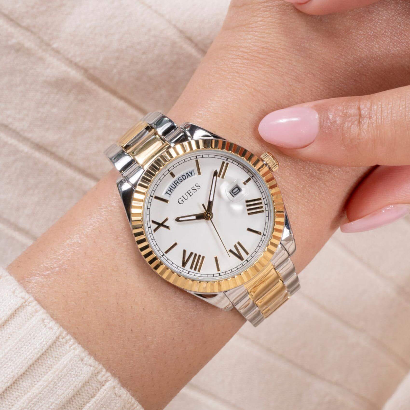 Γυναικείο ρολόι Guess Luna GW0308L6 φορεμένο με δίχρωμο μπρασελέ σε ασημί και χρυσό χρώμα και ασημί καντράν με χρυσές λεπτομέρειες.