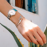 Γυναικείο ρολόι JCOU Aphrodite JU19051-5 φορεμένο στον καρπό, με ασημί μπρασελέ και κρεμ καντράν.