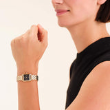 Γυναικείο ρολόι Rosefield Boxelle Black Crystals  BBGSG-B08 με χρύσο μπρασελέ και μαύρο τετράγωνο καντράν με πέτρες, φορεμένο.