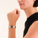 Γυναικείο ρολόι Rosefield Boxelle Black Duotone BBDSG-B07 με δίχρωμο μπρασελέ και μαύρο τετράγωνο καντράν, φορεμένο.