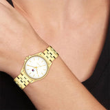 Γυναικείο ρολόι Tommy Hilfiger Jade 1782773 με χρυσό ατσάλινο μπρασελέ και άσπρο καντράν 30mm, φορεμένο.
