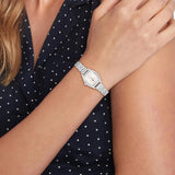 Γυναικείο ρολόι Tommy Hilfiger Norah 1782872 φορεμένο με ασημί μπρασελέ από ανοξείδωτο ατσάλι και λευκό τετράγωνο καντράν με χρυσές λεπτομέρειες.