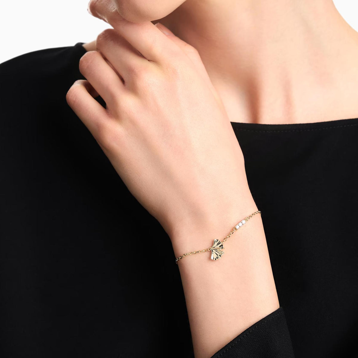 Γυναικείο βραχιόλι Emporio Armani Sentimental EGS3263710 φορεμένο στον καρπό από ορείχαλκο σε χρυσό χρώμα με φύλλο ginkgo και ζιργκόν