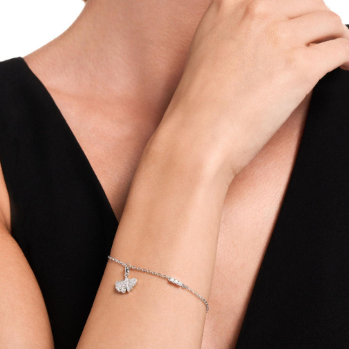 Γυναικείο βραχιόλι Emporio Armani Sentimental EGS3412040 φορεμένο στον καρπό σε ασημί χρώμα με φύλλο ginkgo και ζιργκόν