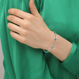 Γυναικείο βραχιόλι Lacoste 2040457 σε ασημί χρώμα. To βραχιόλι έχει διπλή λεπτή αλυσίδα, πράσινες χάντρες και ρυθμιζόμενο κούμπωμα από ανοξείδωτο ατσάλι. 