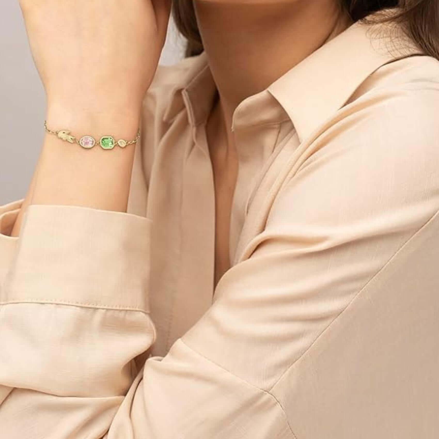 Γυναικείο βραχιόλι Lacoste Deva 2040606 φορεμένο στον καρπό, από ανοξείδωτο ατσάλι σε χρυσό χρώμα με κρύσταλλα.