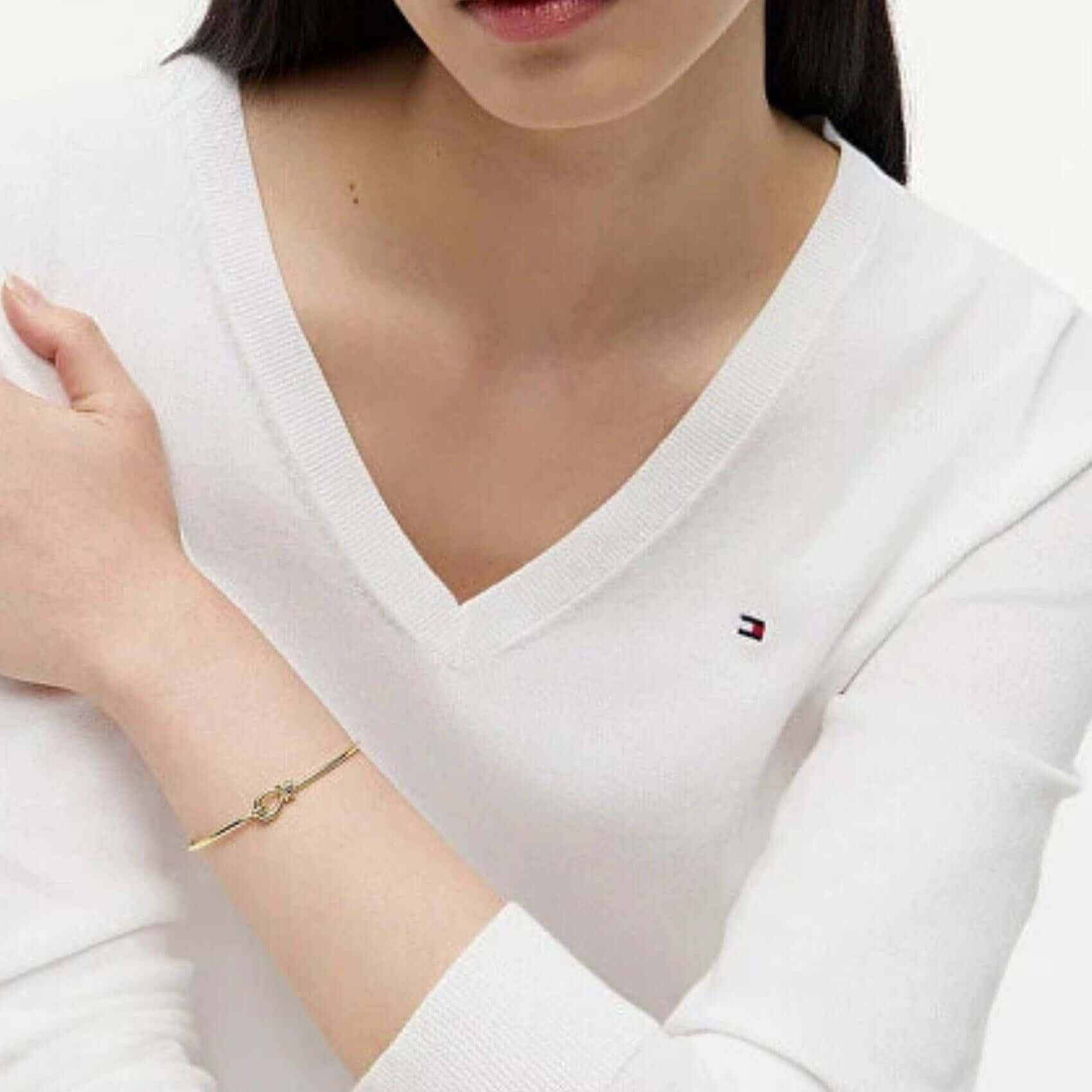 Γυναικείο βραχιόλι Tommy Hilfiger 2781028 φορεμένο στον καρπό, σε χρυσό χρώμα με σχέδιο χειροπέδας.
