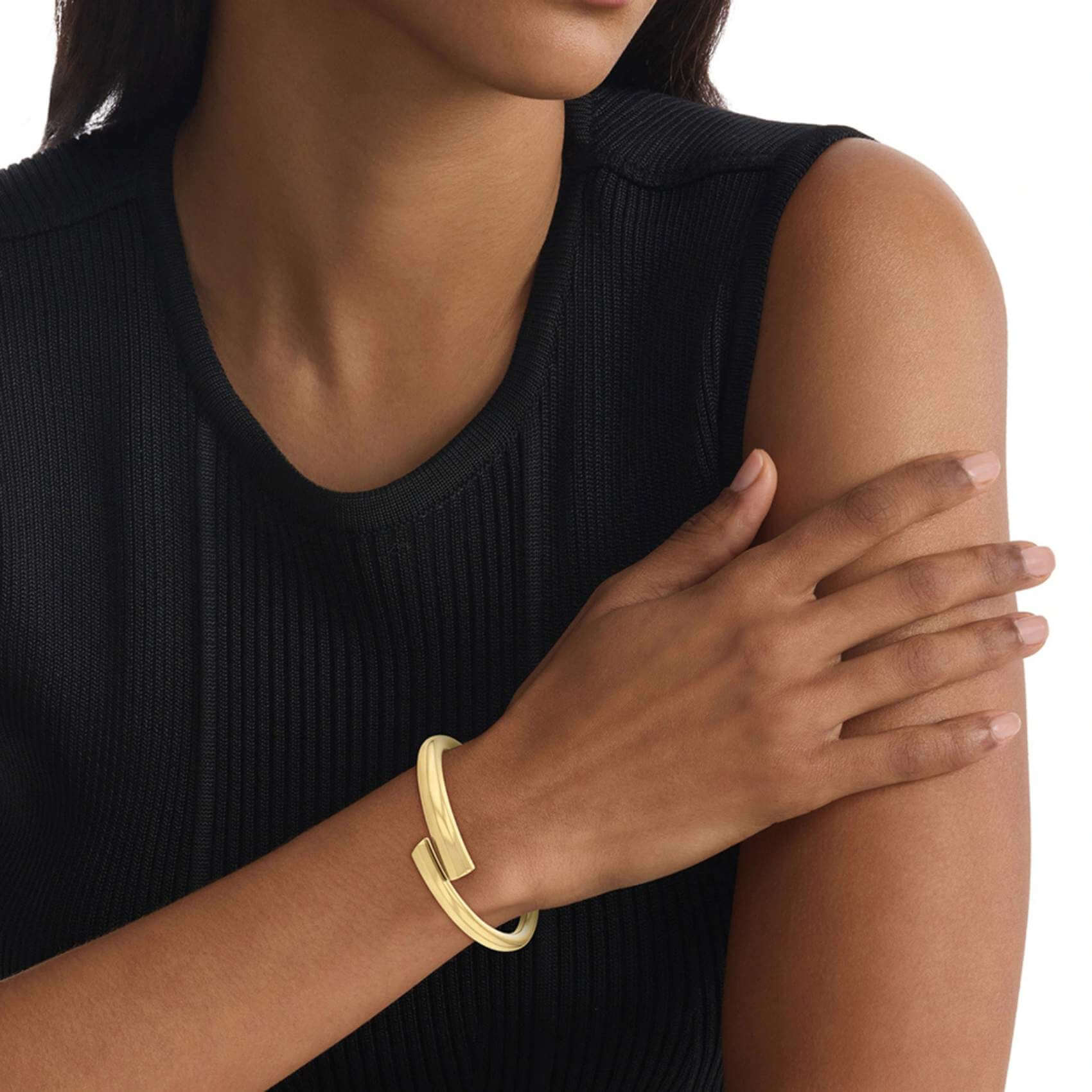 Γυναικείο Βραχιόλι Χειροπέδα Calvin Klein 35000763 ατσάλινο χρυσό με ασσύμετρο σχέδιο, φορεμένο.