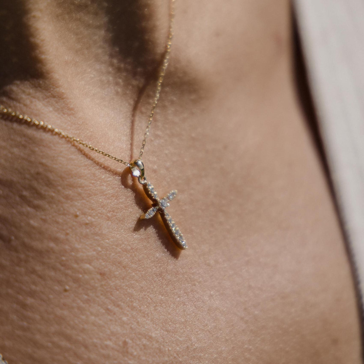 Χρυσός βαπτιστικός σταυρός 18K με διαμάντια και κεντρική πέτρα φορεμένος στο λαιμό