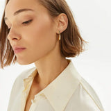 Γυναικεία καρφωτά σκουλαρίκια Calvin Klein 35000607 σταγόνες ατσάλινα σε χρυσό χρώμα, φορεμένα.
